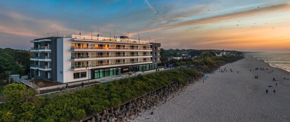A modern hotel with multiple balconies, situated by a beach. - Baltivia Sea Resort (Mielno)
