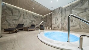 Un espace de détente avec un jacuzzi, des chaises longues et un plafond en bois.