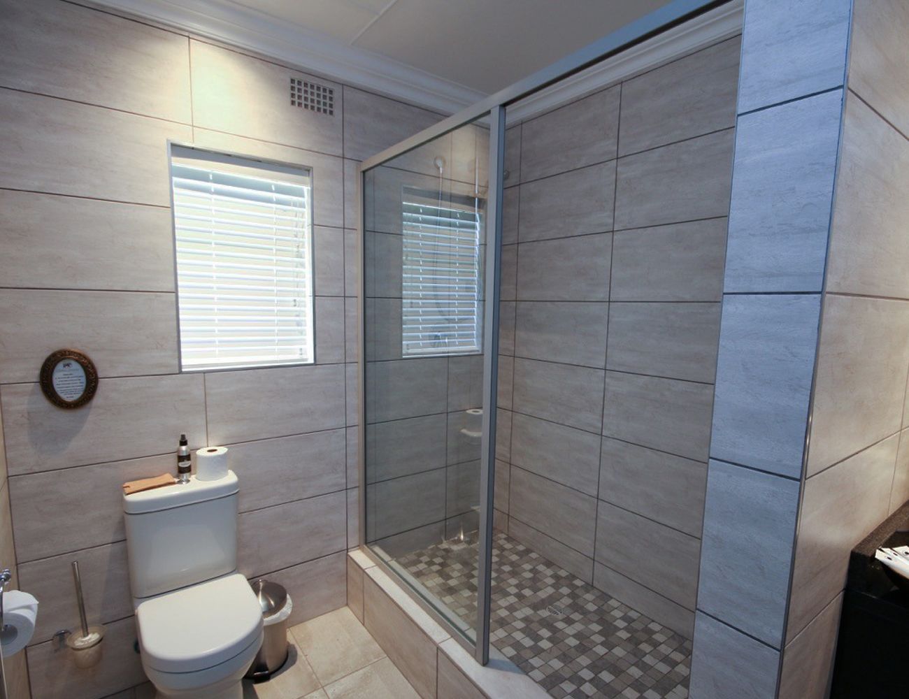A modern bathroom with a toilet, bidet, and shower enclosure.