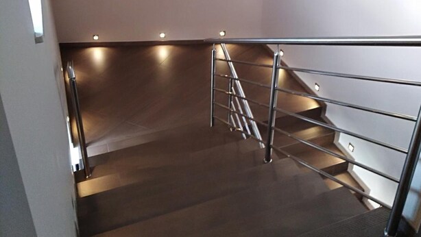 A modern staircase with metal railings and a dark wooden finish. - Hotel Nekla (Nekla)