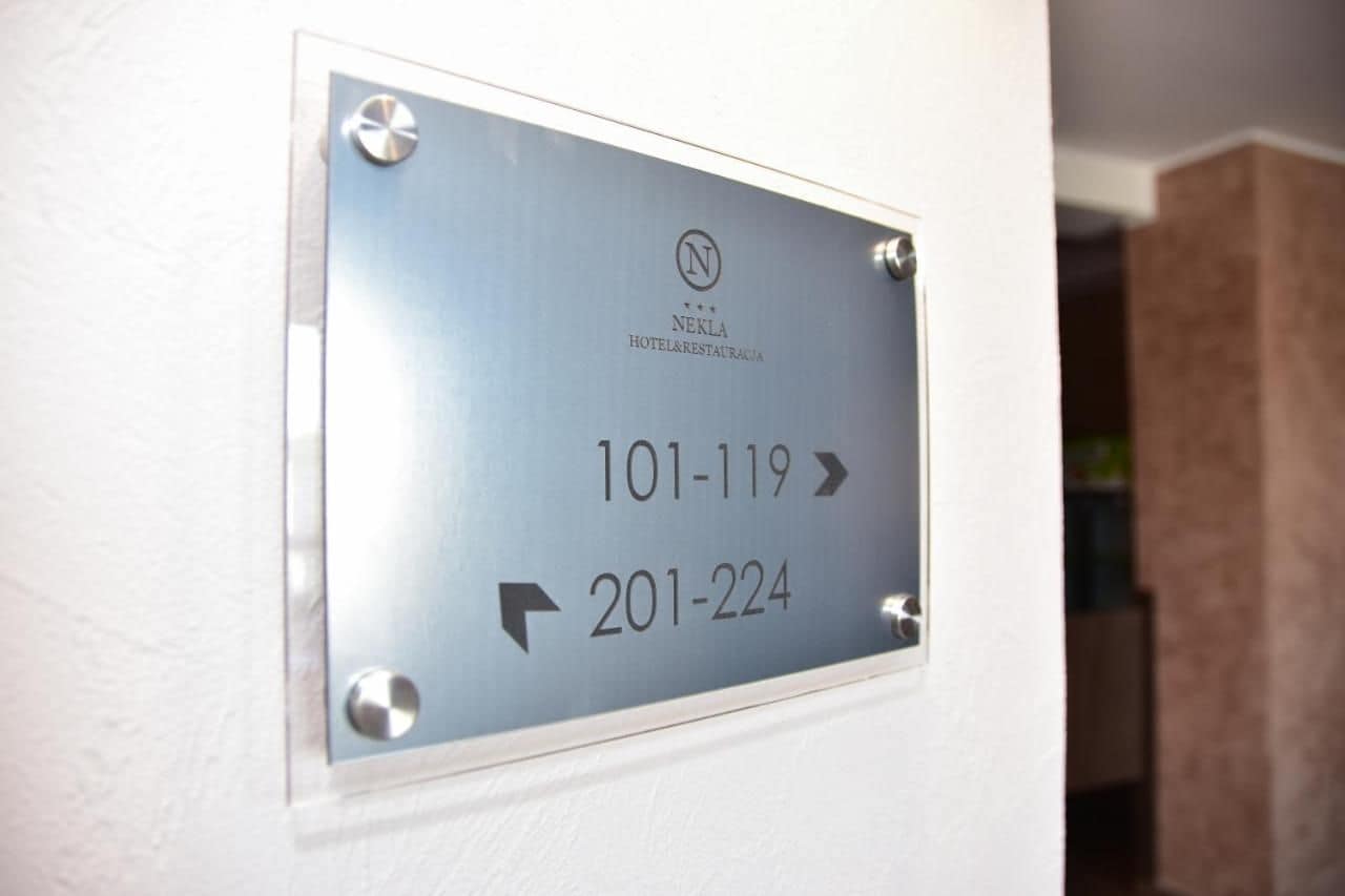 A sign with contact numbers and directions for hotel services.
