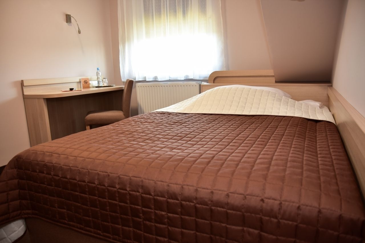 Una habitación de hotel con una cama, un escritorio y una silla.