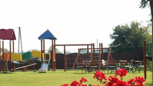 A playground with various play structures and a seating area with chairs. - Hotel Nekla (Nekla)