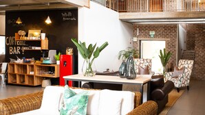 A modern lounge area with a bar, seating, and a staircase. - Execustay (Mbombela)