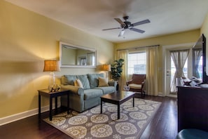 A living room with a sofa, coffee table, and a ceiling fan. - New Hotel Collection Harbourside Resort (Indian Rocks Beach)