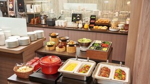 A buffet setup with various food items and condiments. - Keio Presso Inn Kudanshita (Tokyo)
