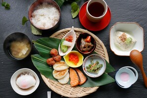 Savor a traditional Japanese meal on a woven mat, served with a variety of dishes and condiments.