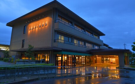 A modern hotel with a two-story structure, large windows, and a well-lit entrance.