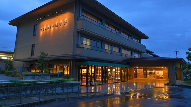 A modern hotel with a two-story structure, large windows, and a well-lit entrance.
