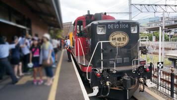 A train at a station with passengers waiting on the platform.