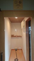 A designated smoking room with a wooden floor, a small table, and a picture frame on the wall.