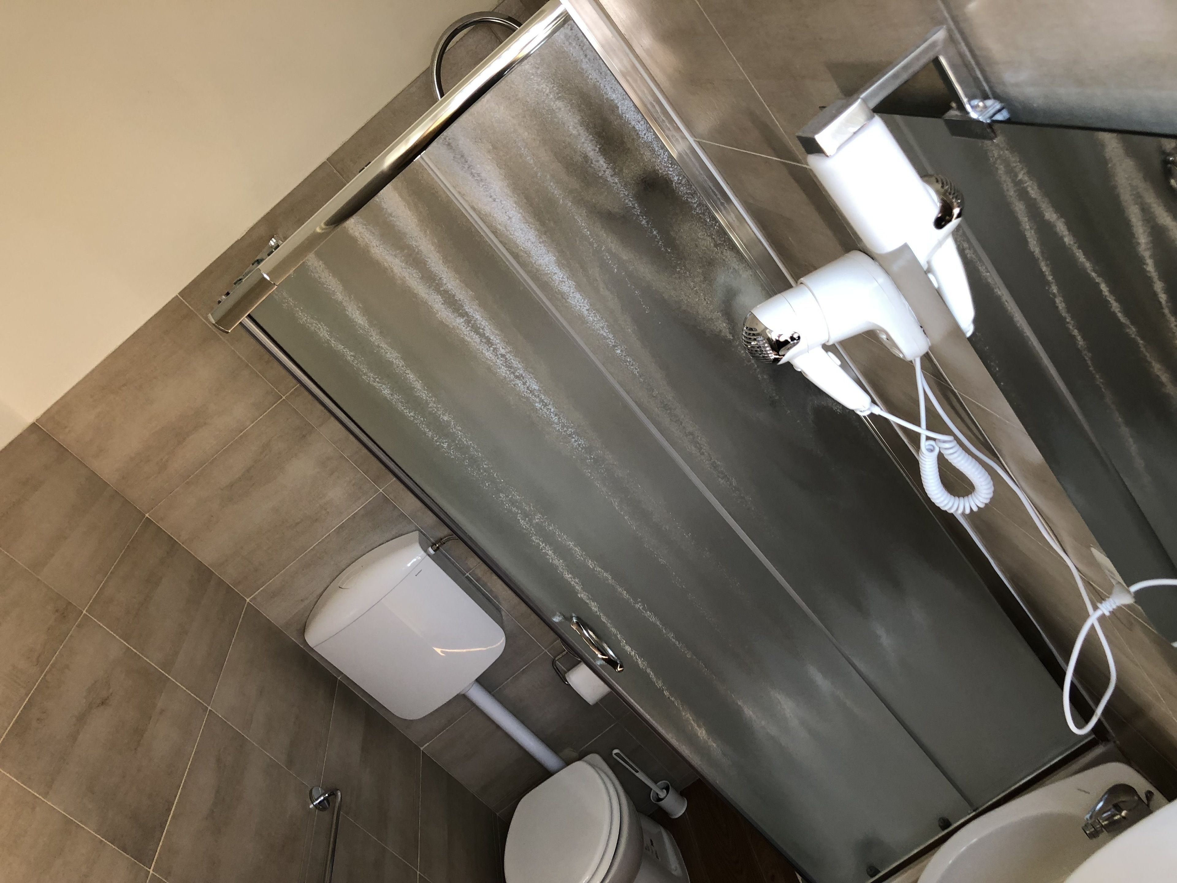 A bathroom with a shower, toilet, and sink.