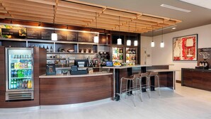 Un área de bar moderna con techo de madera, dispensador de bebidas refrigerado y taburetes de bar.