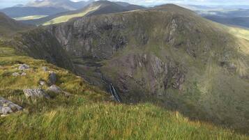 A mountainous landscape with a valley and a waterfall.