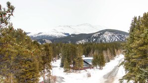 A cabin surrounded by snow-covered mountains and pine trees. - Mark IX 9 by Peak Property (Breckenridge)