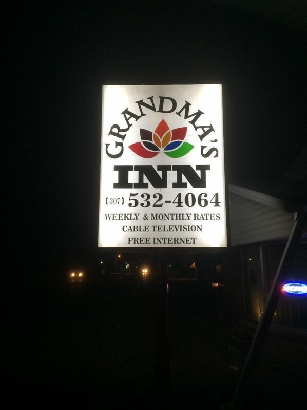 A sign for Grandma's Inn with a phone number and services like weekly & monthly rates, cable television, and free internet.