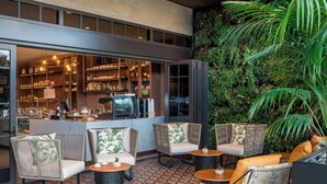 An outdoor seating area with wicker furniture and a patterned floor. - The Dalmar, Fort Lauderdale, a Tribute Portfolio Hotel (Fort Lauderdale)