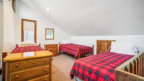 Un dormitorio con dos camas, un aparador de madera y un espejo.