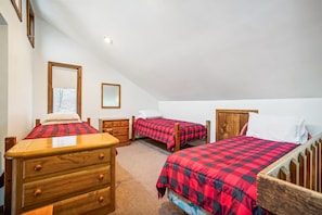 A bedroom with two beds, a wooden dresser, and a mirror. - Welcome to your ideal mountain escape! This delightful 3-bedroom plus loft (Killington)
