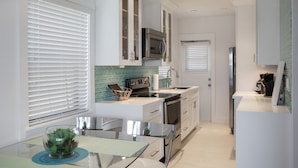 A modern kitchen with white cabinets, a stainless steel refrigerator, and a microwave. - Direct Ocean & Boardwalk Views - Beautifully Appointed Condo - Parking & Wi-Fi (Hollywood)
