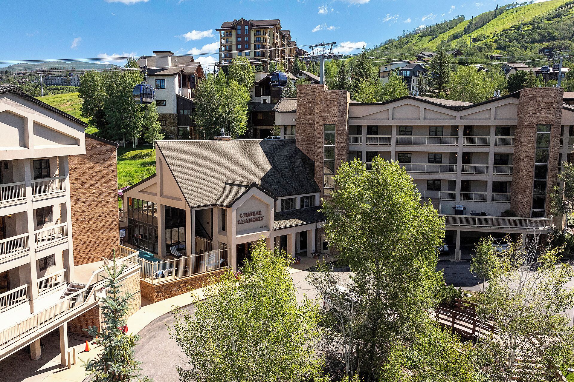The Chateau Chamonix nestles in a picturesque mountain village, surrounded by lush hillsides and alpine architecture, offering a serene arrival experience.