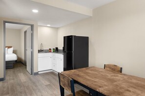 A compact hotel room with a kitchenette, a dining area, and a bed. - Days Inn by Wyndham Safford, AZ (Safford)