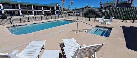 Un espace piscine avec des chaises longues et un panneau indiquant « Days Inn ».