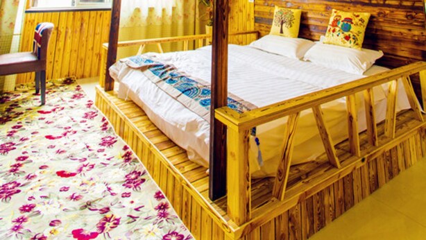 A wooden four-poster bed with a starry ceiling, a floral carpet, and a window with curtains. - Wuzhen Youyou Inn (Jiaxing)