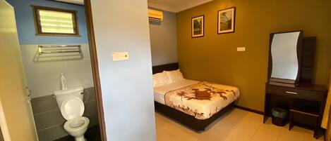 A bedroom with a bed, a bedside table, a mirror, and a wall-mounted air conditioner.
