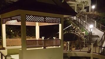 Stunning multi-level building with a grand staircase and covered area, surrounded by lush gardens.