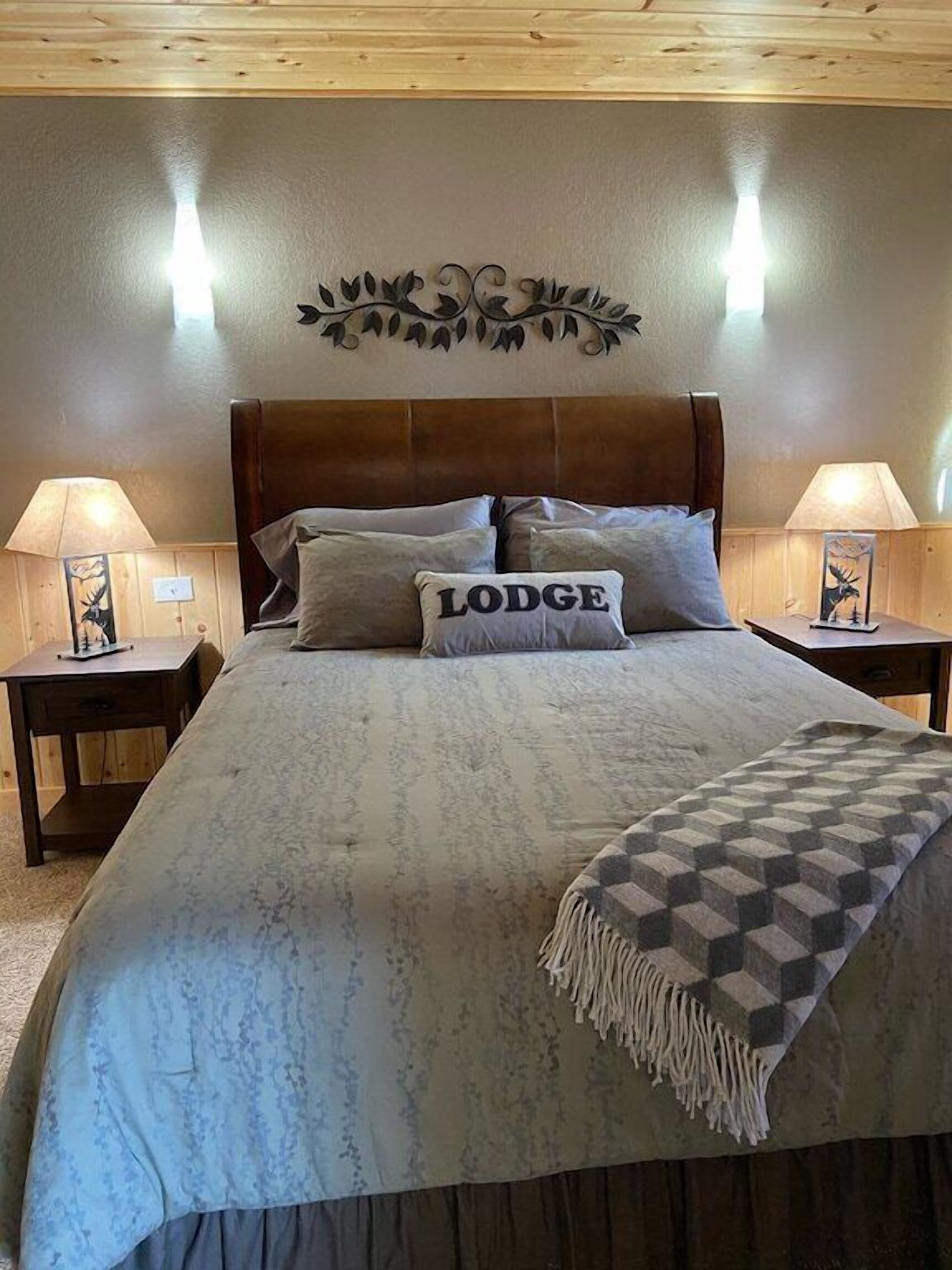 Un dormitorio con una cama grande, dos mesitas de noche y un cabecero.