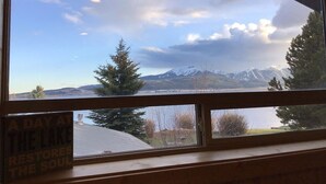 A view through a window with a sign that reads "A DAY AT THE LAKE RESTORES THE SOUL".