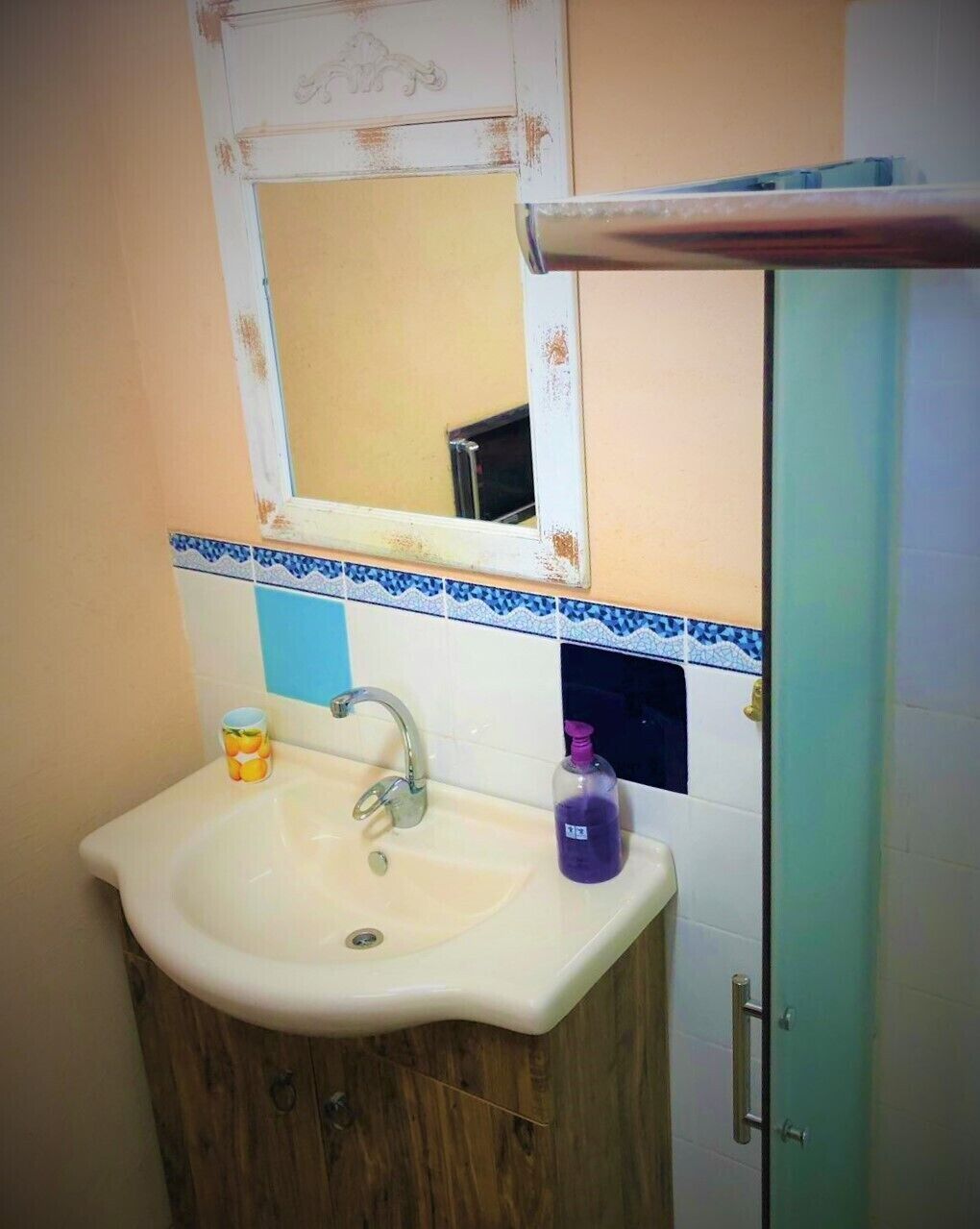 Een badkamer met een wastafel, spiegel en kast.