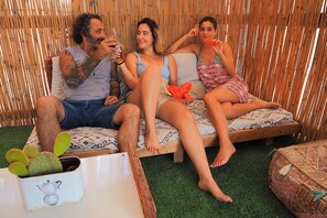 Un grupo de personas sentadas en una cama frente a un fondo de bambú.