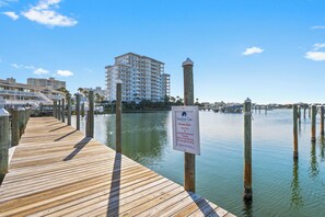A wooden pier leading to a private dock with a sign indicating amenities like a water taxi and restaurant.