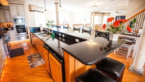 A modern kitchen with a central island, stainless steel appliances, and wooden cabinetry.