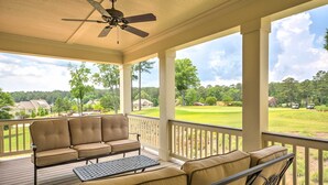 A covered outdoor area with a sofa and table, overlooking a golf course. - Spacious Family-Friendly Retreat w/ Winter Rates! (Greensboro)