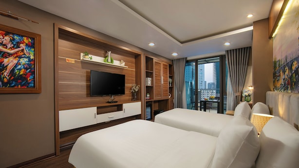 Habitación de hotel con dos camas, televisión, paneles de madera y vistas a la ciudad.