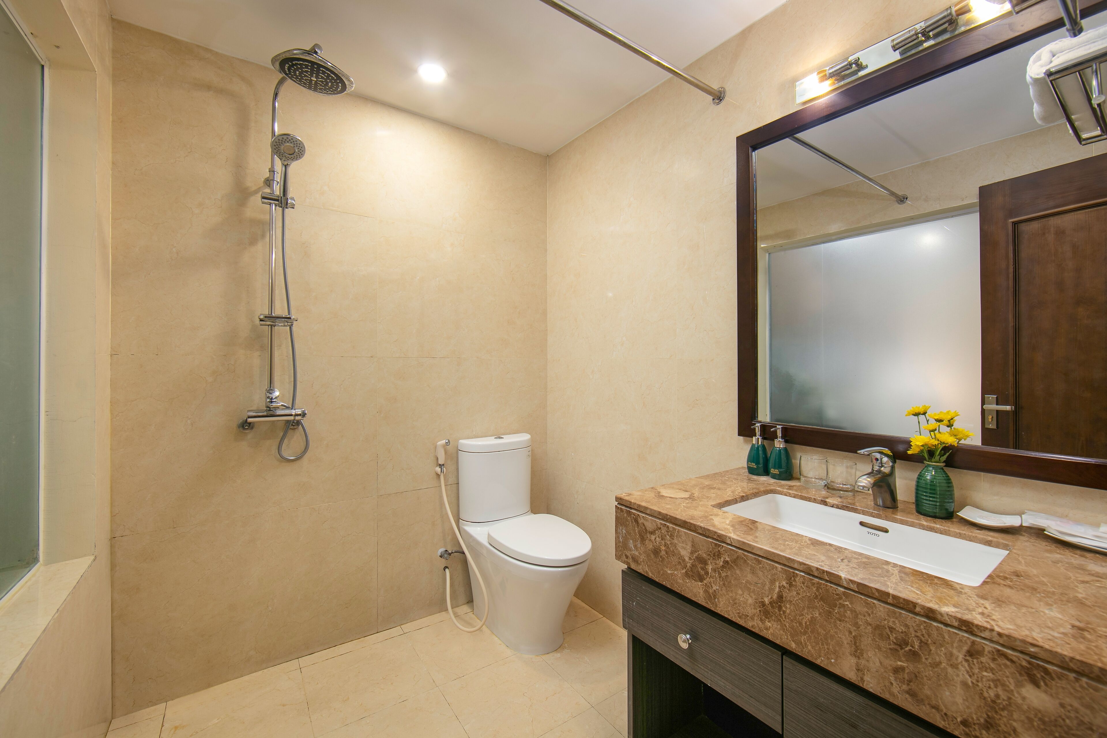 Un baño moderno con ducha, inodoro, lavabo y espejo.