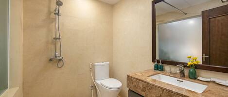 A modern bathroom with a shower, toilet, sink, and mirror.