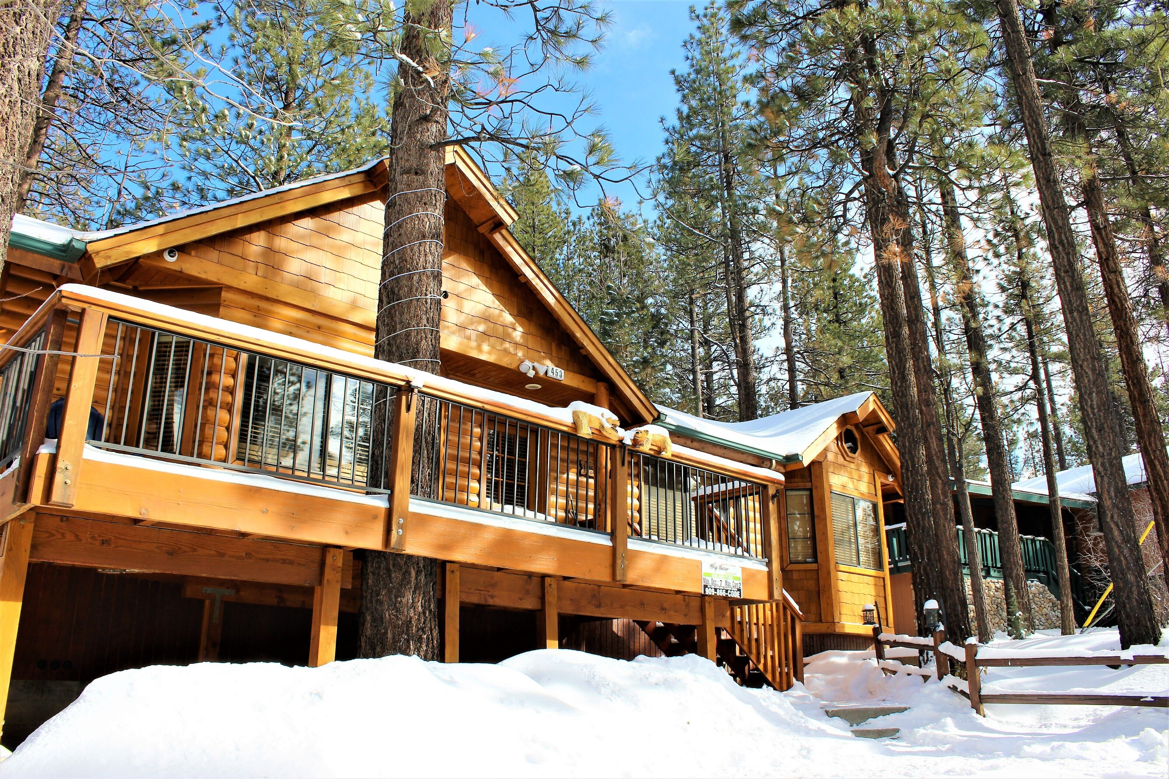 Welcoming cabin entry surrounded by towering pine trees, offering fresh mountain air and a peaceful forest setting—the perfect first impression for your Big Bear Lake getaway.