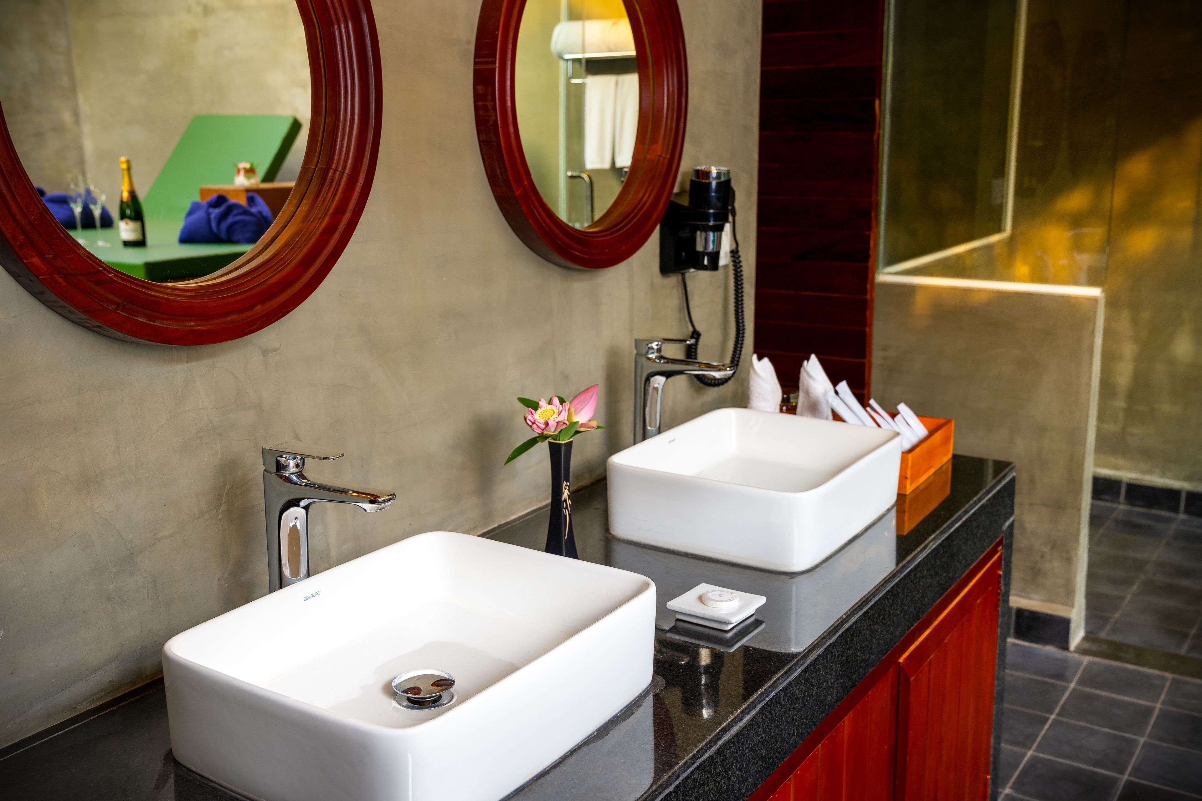 A bathroom with two sinks, a mirror, and a vanity.