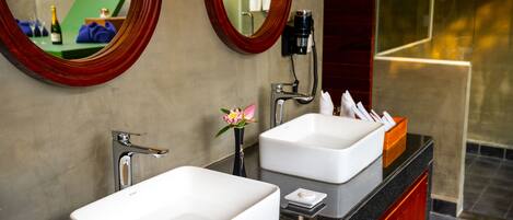 A bathroom with two sinks, a mirror, and a vanity.