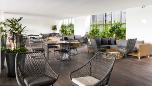 Un vaste espace extérieur aménagé avec des meubles en osier, un canapé et une table basse.