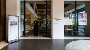 Une entrée moderne avec des portes en verre, une enseigne indiquant « Ouvert maintenant » et un panneau affichant le menu sur le côté gauche.