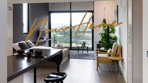 Un intérieur moderne comprenant un espace cuisine, un coin repas et un salon avec vue.
