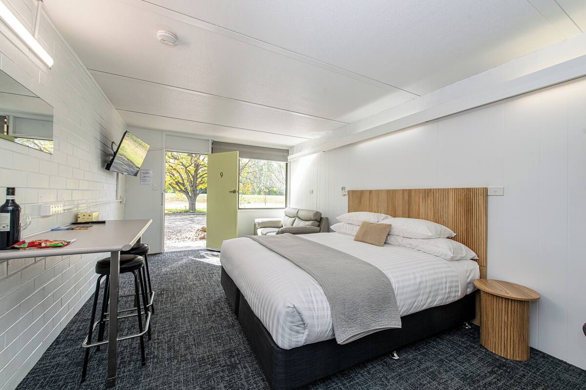 A modern bedroom with a bed, a desk, and a chair.