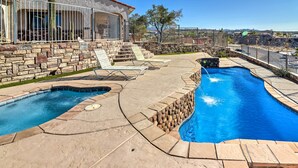 A swimming pool with a stone wall and a small waterfall feature.