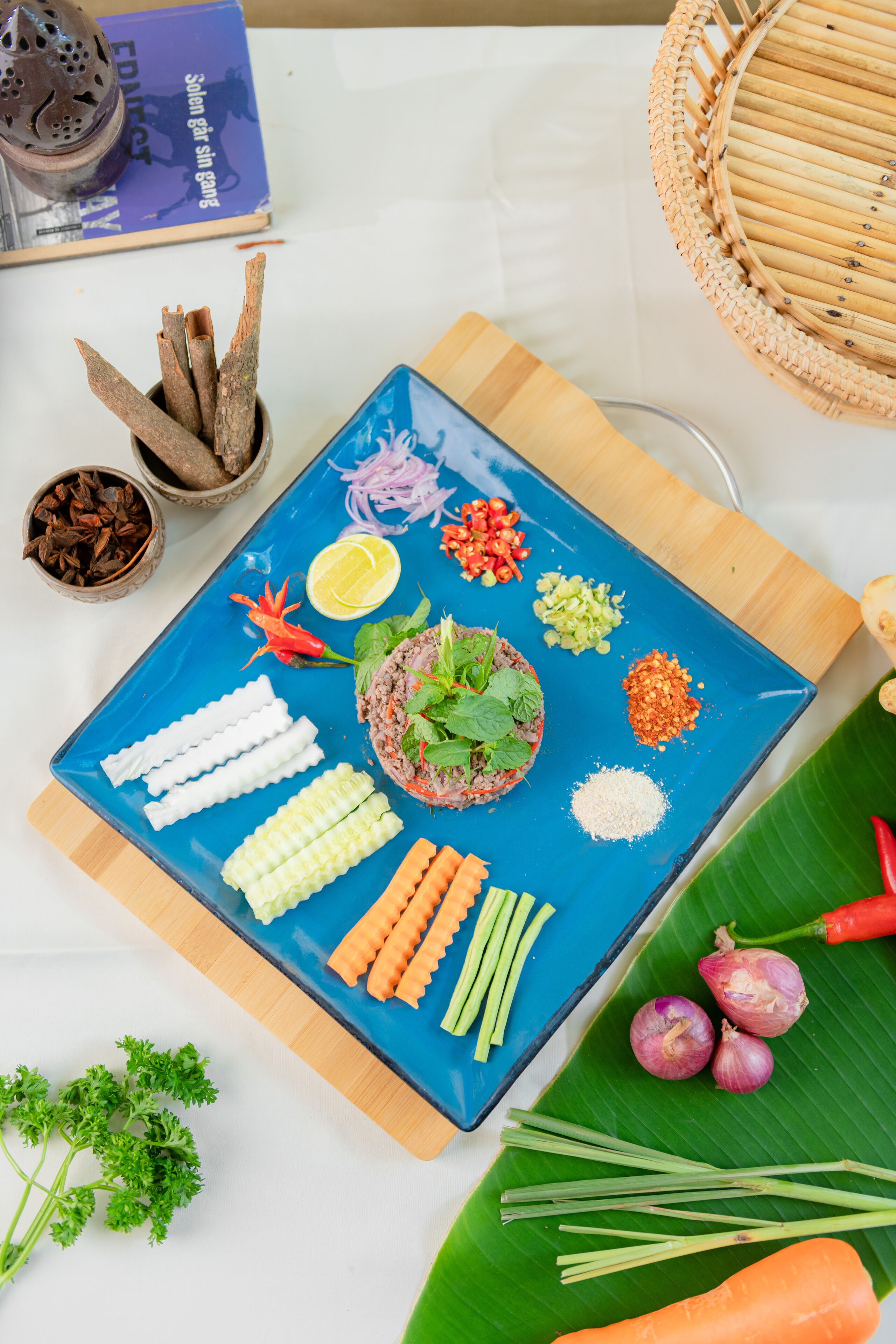 A table with a blue plate containing various food items and ingredients.