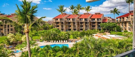 A resort with multiple buildings, a swimming pool, and lush greenery.